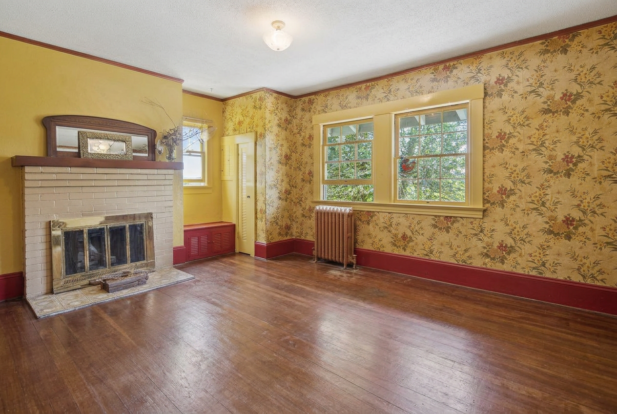 Bedroom with its own brick fireplace and period wallpaper, shown vacant