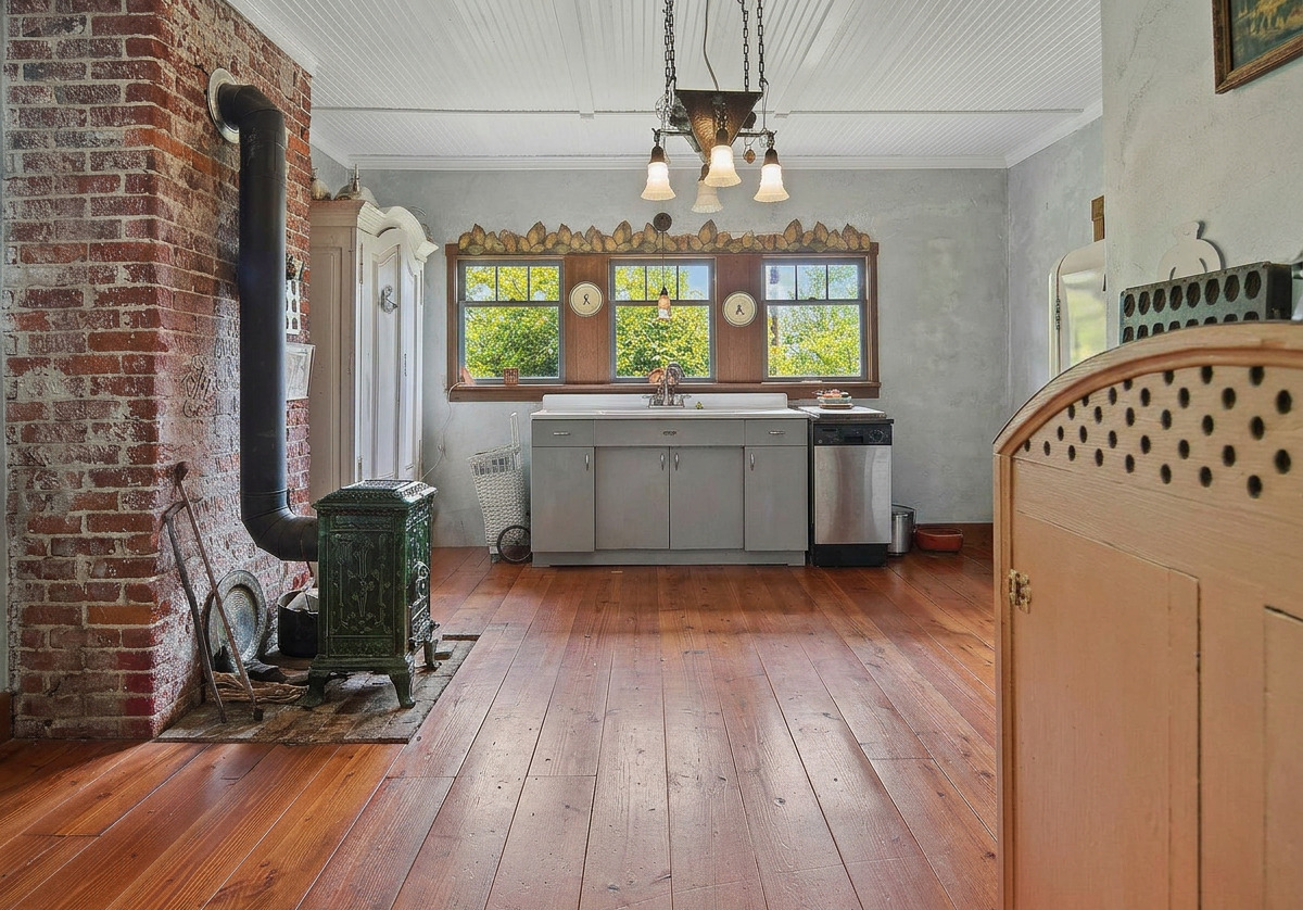 Kitchen with exposed brick chimney and wide-plank floors
