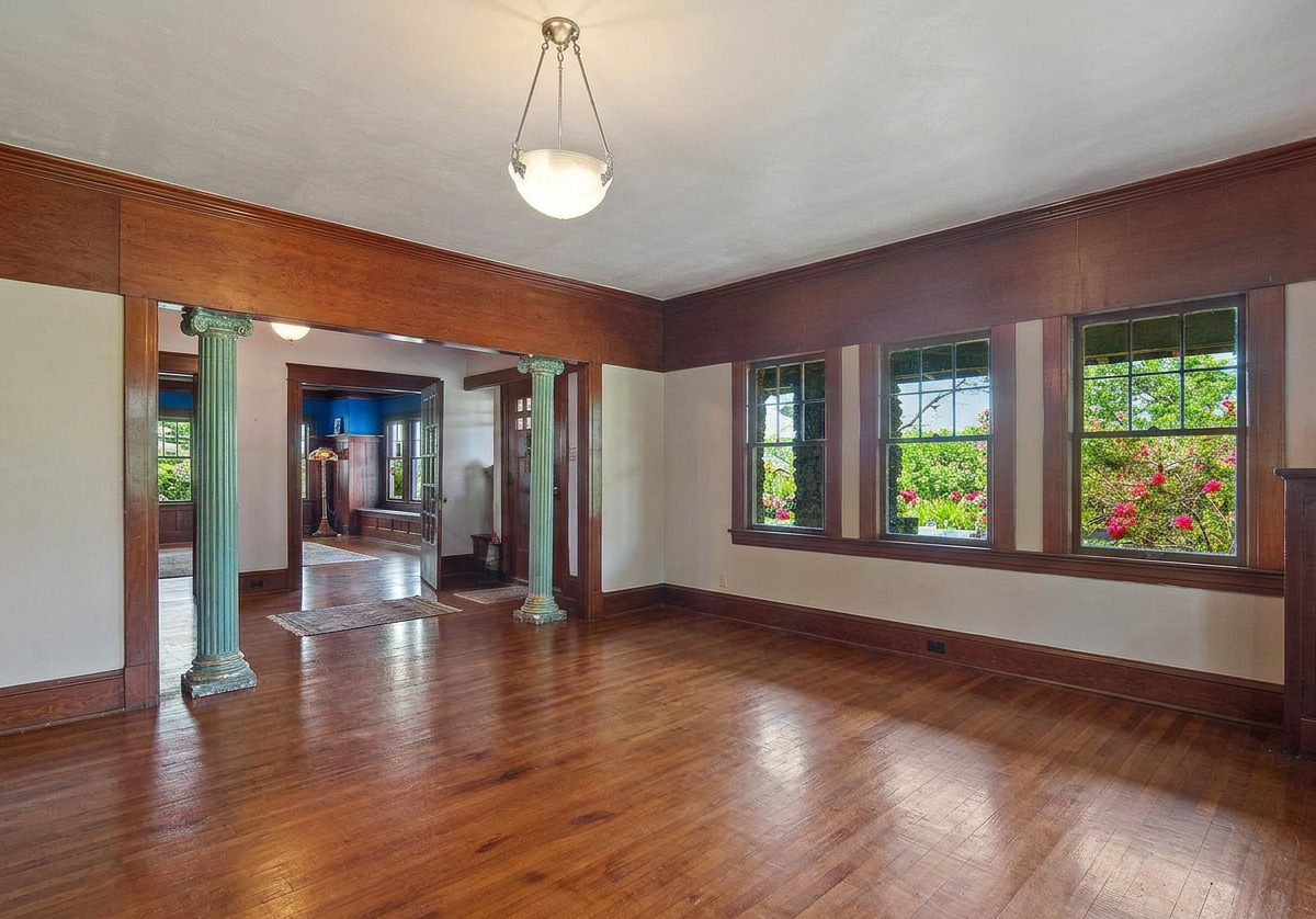 Principal living room with original columns and millwork, shown vacant